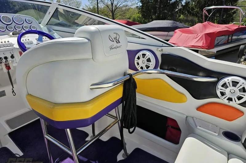 Slide: The Image of Interior of a 2001 Powerquest 340 Vyper boat with colorful seating and control panel. - 54