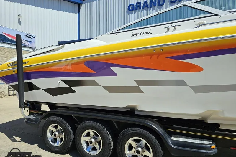Slide: The Image of 2001 Powerquest 340 Vyper boat with vibrant graphics on a trailer at Grand Sport Center. - 6