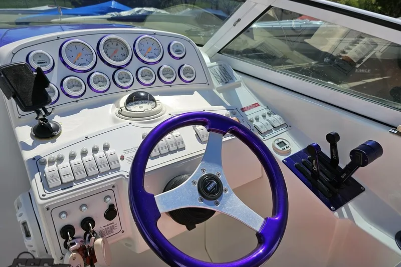 Slide: The Image of 2001 Powerquest 340 Vyper boat dashboard with gauges, purple steering wheel, and control levers. - 61