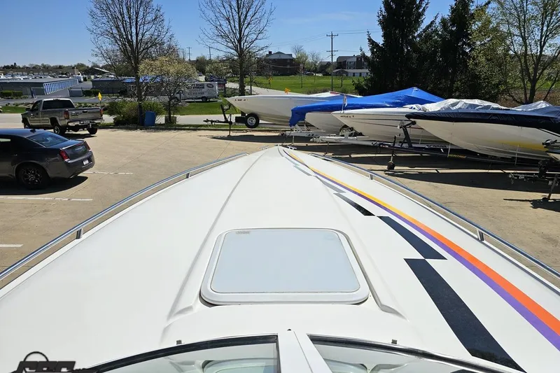 Slide: The Image of 2001 Powerquest 340 Vyper boat parked outdoors, surrounded by other boats and vehicles. - 65