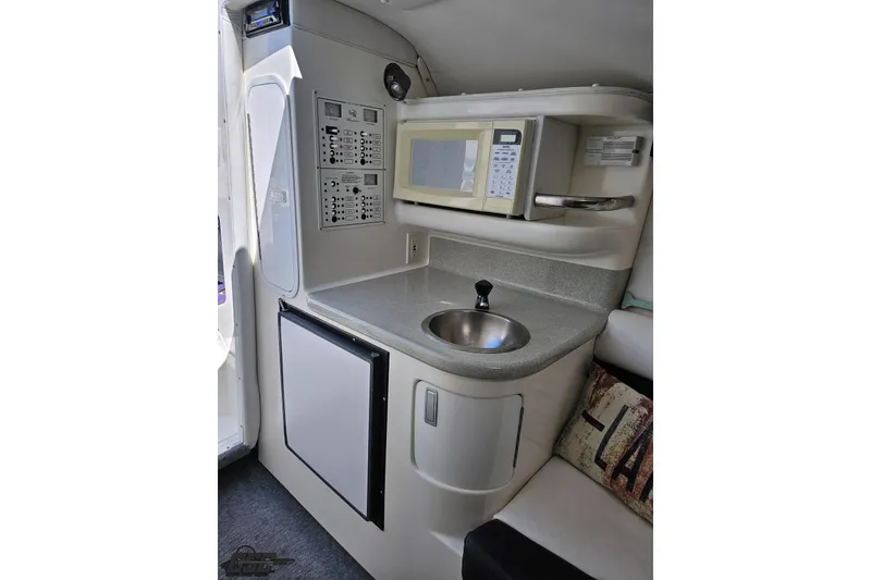 Slide: The Image of 2001 Powerquest 340 Vyper boat interior with kitchenette, microwave, sink, and control panel. - 71