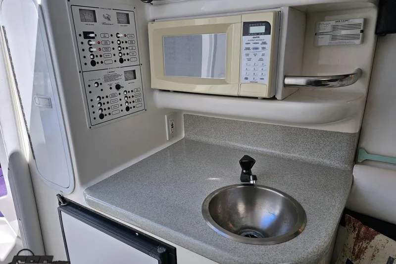Slide: The Image of 2001 Powerquest 340 Vyper boat interior with microwave, sink, and control panels. - 72