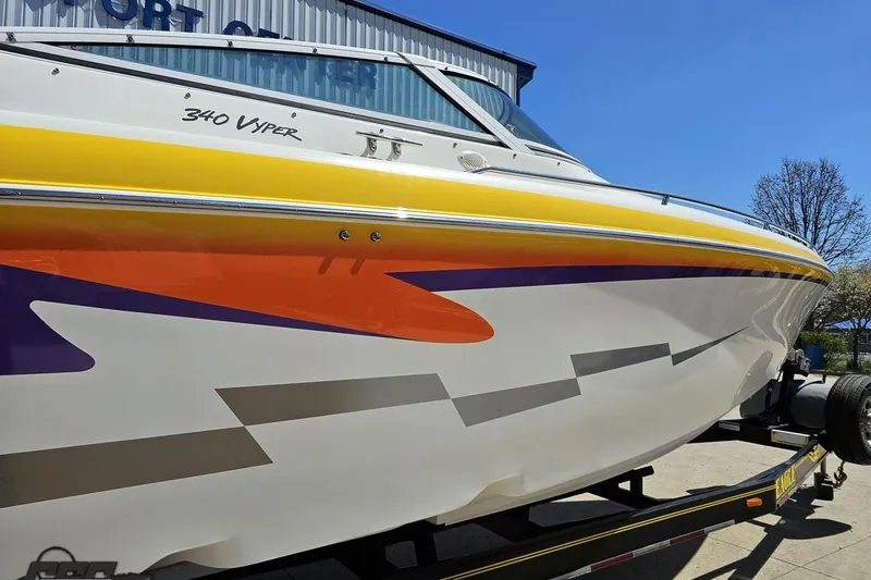 Slide: The Image of 2001 Powerquest 340 Vyper boat with vibrant graphics on a trailer. - 8