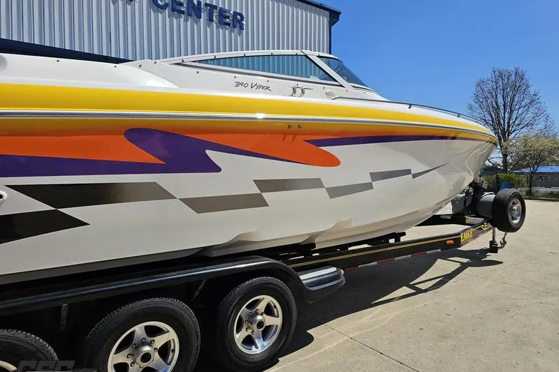 Slide: The Image of 2001 Powerquest 340 Vyper boat with vibrant graphics on a trailer. - 9
