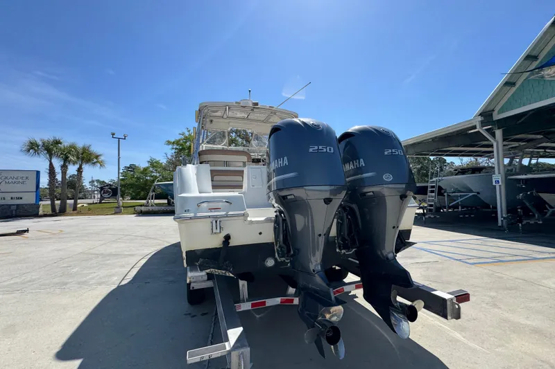 Slide: The Image of 2004 Wellcraft 290 Coastal boat with twin Yamaha 250 engines in a marina setting. - 15
