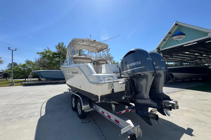 Slide: The Image of 2004 Wellcraft 290 Coastal boat on trailer with Yamaha engines, parked outdoors. - 16