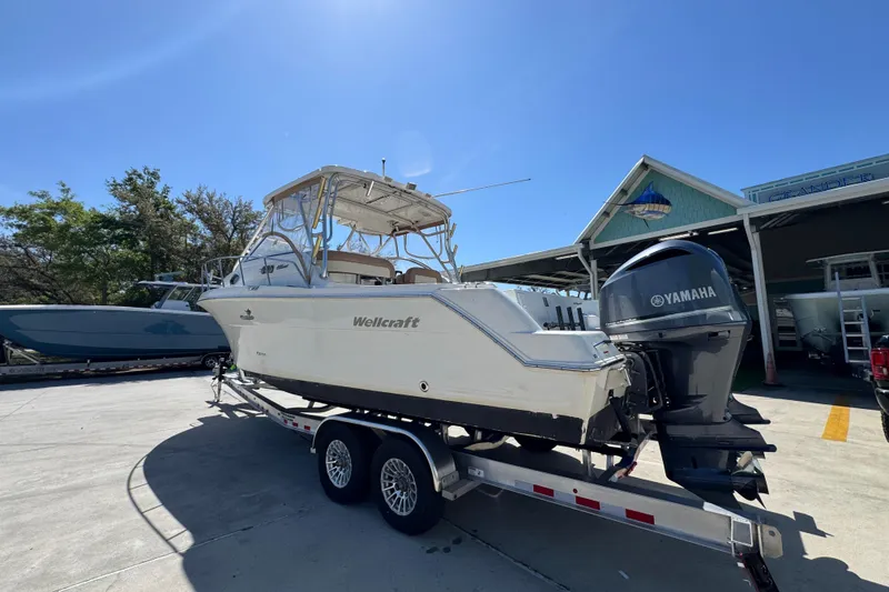 Slide: The Image of 2004 Wellcraft 290 Coastal boat on trailer with Yamaha outboard motor, parked outdoors. - 17