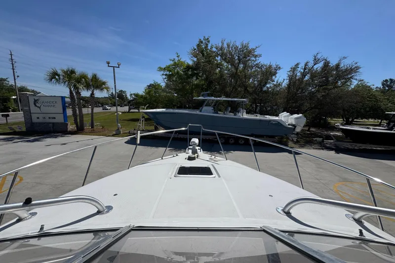 Slide: The Image of 2004 Wellcraft 290 Coastal boat at Grander Marine dealership under clear blue sky. - 18