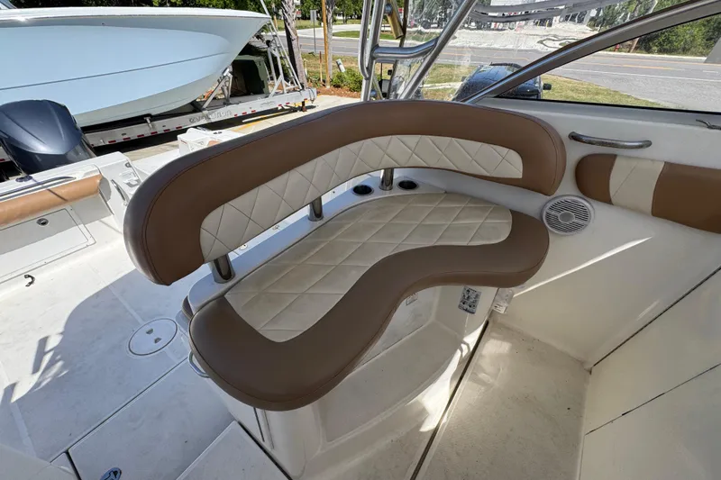 Slide: The Image of 2004 Wellcraft 290 Coastal boat interior with brown and white cushioned seating. - 24