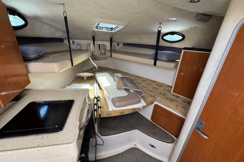 Slide: The Image of 2004 Wellcraft 290 Coastal cabin interior with beds, kitchenette, and storage. - 28