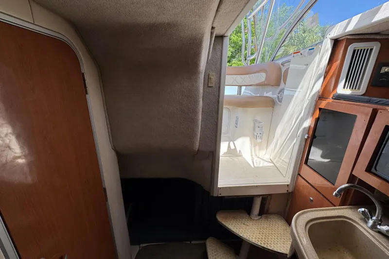 Slide: The Image of Interior view of 2004 Wellcraft 290 Coastal boat, featuring cabin stairs and kitchenette area. - 29