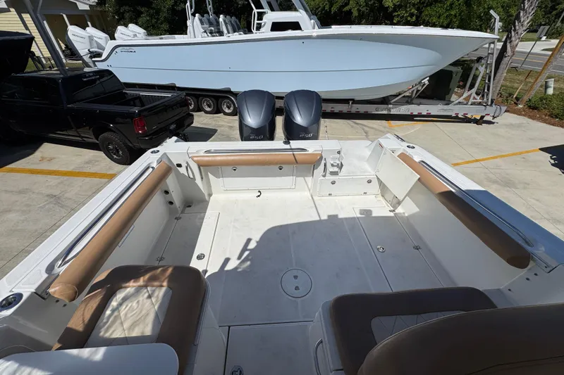 Slide: The Image of 2004 Wellcraft 290 Coastal boat interior with twin engines, parked near a trailer and truck. - 31