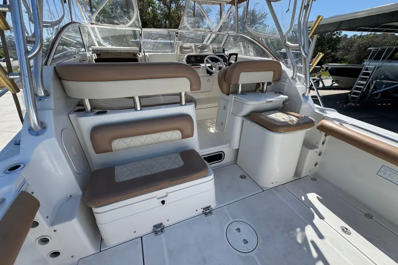 Slide: The Image of 2004 Wellcraft 290 Coastal boat interior with cushioned seating and helm station. - 32