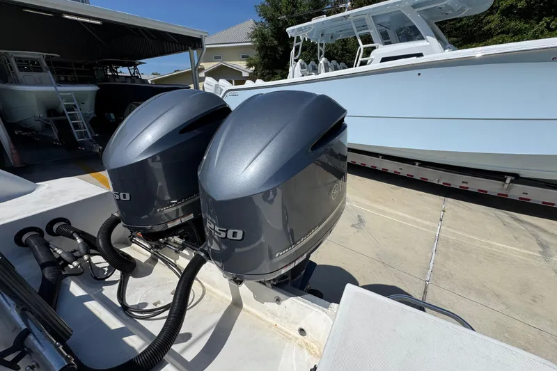 Slide: The Image of 2004 Wellcraft 290 Coastal boat with twin outboard engines in a marina setting. - 36