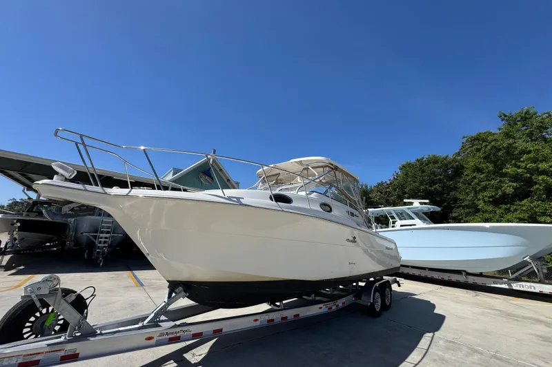 Slide: The Image of 2004 Wellcraft 290 Coastal boat on trailer under clear blue sky. - 4