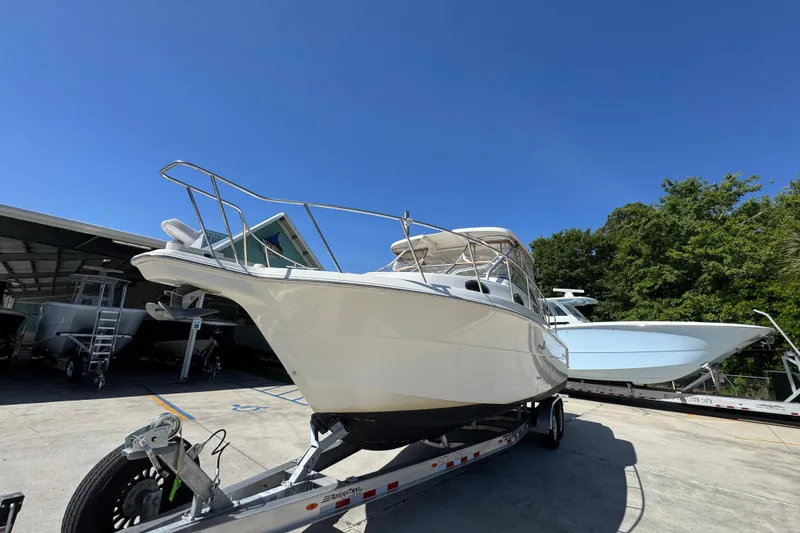 Slide: The Image of 2004 Wellcraft 290 Coastal boat on trailer under clear blue sky. - 5