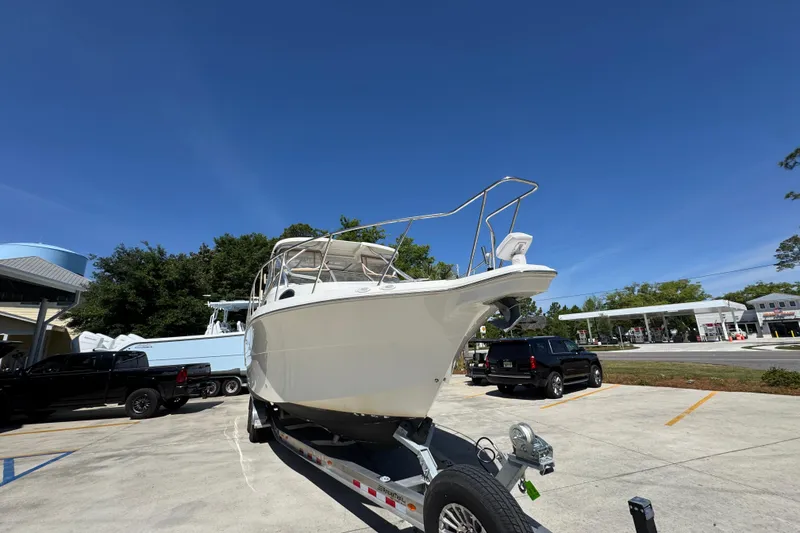 Slide: The Image of 2004 Wellcraft 290 Coastal boat on trailer in parking lot under clear blue sky. - 7