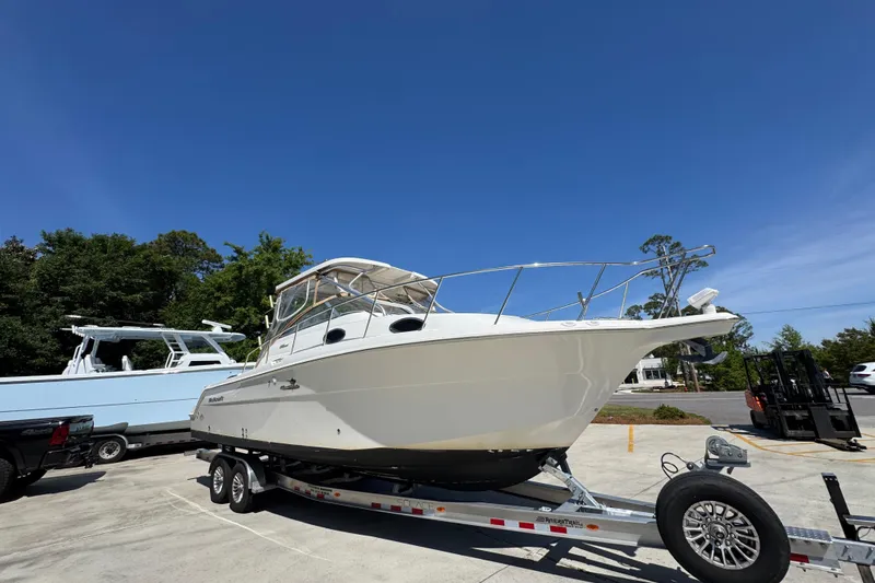 Slide: The Image of 2004 Wellcraft 290 Coastal boat on trailer under clear blue sky. - 8