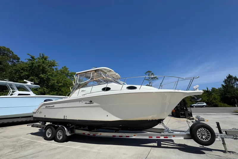 Slide: The Image of 2004 Wellcraft 290 Coastal boat on trailer under clear blue sky. - 9