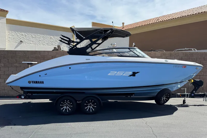 The Image of 2024 Yamaha Boats 252XE, sleek design, parked on trailer, side view. - 0