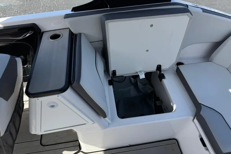 Slide: The Image of 2024 Yamaha Boats 252XE interior storage compartment with open lid, showcasing sleek design and functionality. - 27