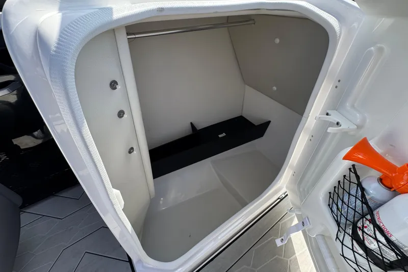 Slide: The Image of 2024 Yamaha Boats 252XE interior storage compartment with safety equipment and modern design. - 32