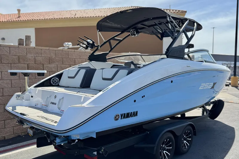 Slide: The Image of 2024 Yamaha Boats 252XE, sleek design, white exterior, parked on trailer. - 5