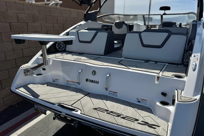 Slide: The Image of 2024 Yamaha Boats 252XE, rear view with seating and table, showcasing modern design. - 6