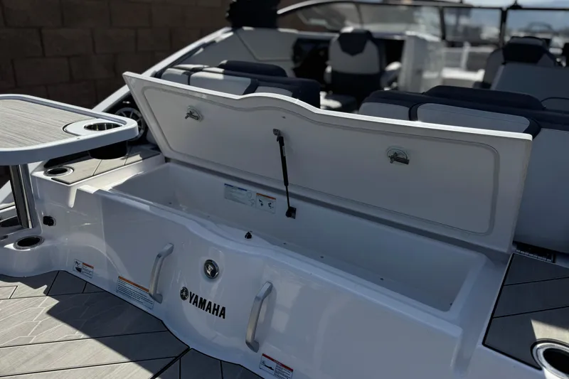 Slide: The Image of 2024 Yamaha Boats 252XE interior with open storage compartment and seating area. - 7