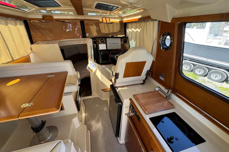 Slide: The Image of Interior of 2026 Ranger Tugs R-25 boat with wood accents and modern amenities. - 10