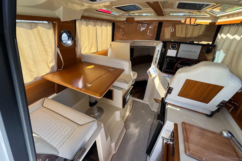 Slide: The Image of Interior of 2026 Ranger Tugs R-25 boat with wood accents and Garmin navigation system. - 11