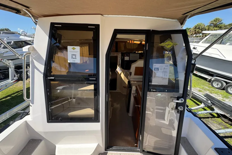 Slide: The Image of 2026 Ranger Tugs R-25 boat interior view with open doors, showcasing cabin layout. - 12