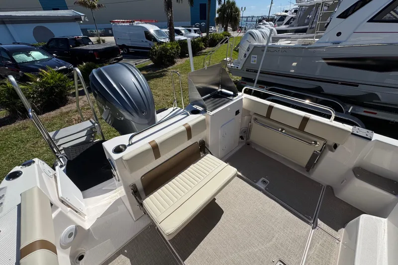 Slide: The Image of 2026 Ranger Tugs R-25 boat interior with seating and outboard motor. - 13