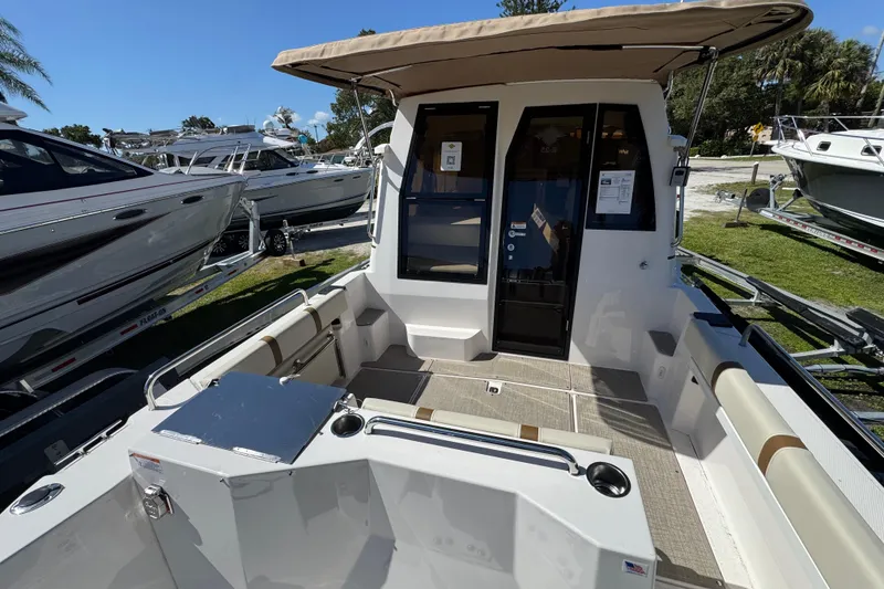 Slide: The Image of 2026 Ranger Tugs R-25 boat interior with seating and canopy, displayed outdoors. - 14