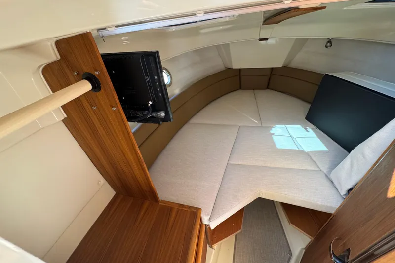 Slide: The Image of Interior cabin of 2026 Ranger Tugs R-25 with cozy seating and wood accents. - 6