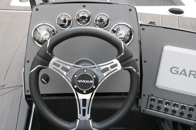 Slide: The Image of Steering wheel and dashboard of 2026 Vexus ADX 190 boat with gauges and controls. - 26