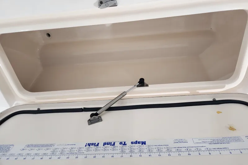 Slide: The Image of Storage compartment with blue and black fabric inside a 2007 Grady-White Tournament 225 boat. - 23