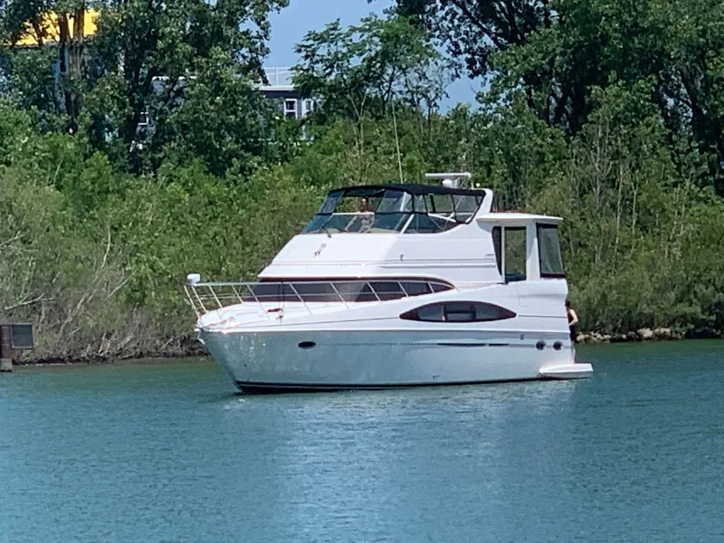 The Image of 2002 Carver 466 Motor Yacht on calm water near trees. - 0