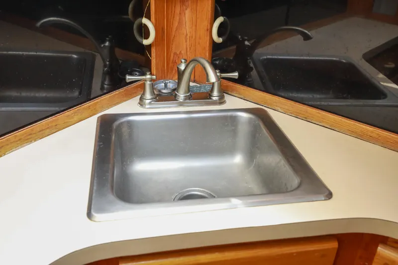 Slide: The Image of 1991 Silverton 41 Aft Cabin kitchen with wood cabinetry, stainless appliances, and compact design. - 17