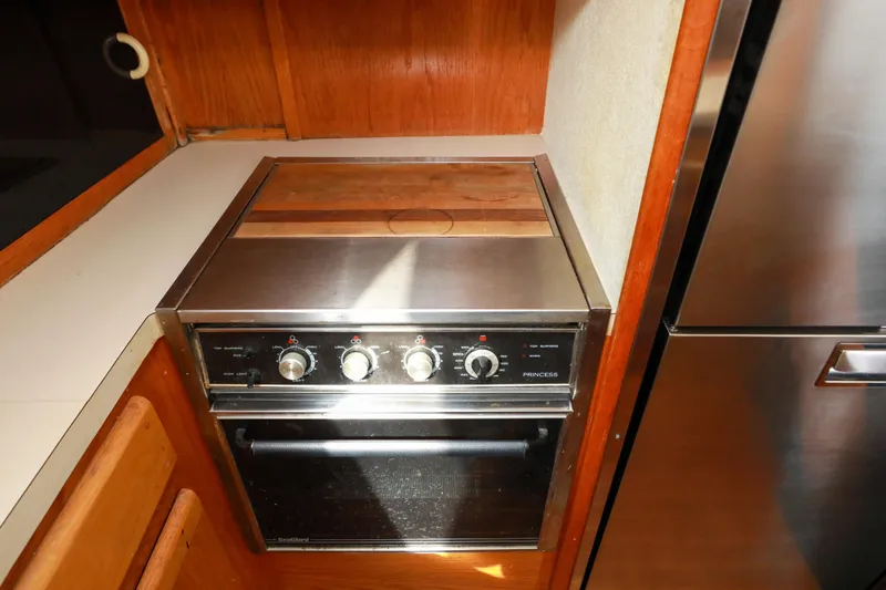 Slide: The Image of 1991 Silverton 41 Aft Cabin kitchen with stainless steel appliances and wood flooring. - 20
