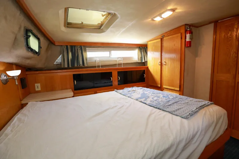 Slide: The Image of Cozy bedroom in 1991 Silverton 41 Aft Cabin yacht with wood cabinetry and nautical decor. - 28