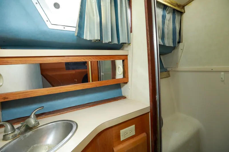 Slide: The Image of 1991 Silverton 41 Aft Cabin interior with cozy bed, wooden cabinets, and natural light. - 30