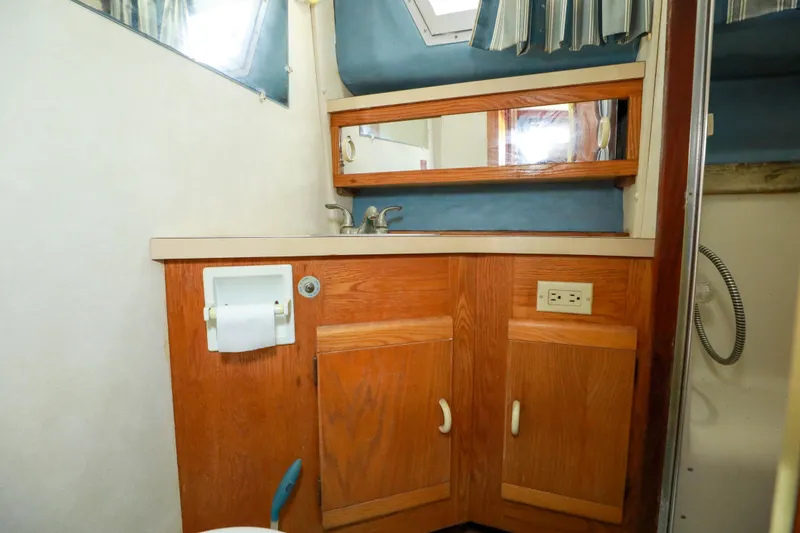Slide: The Image of 1991 Silverton 41 Aft Cabin bathroom with sink, mirror, and wooden cabinetry. - 32
