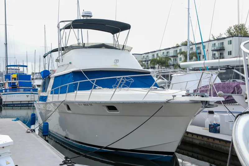 Slide: The Image of 1991 Silverton 41 Aft Cabin yacht docked at marina, featuring blue accents and spacious design. - 5