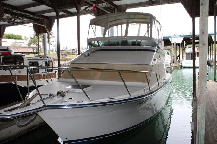 The Image of 1988 Tollycraft 30 Sport Cruiser docked in a covered marina. - 0