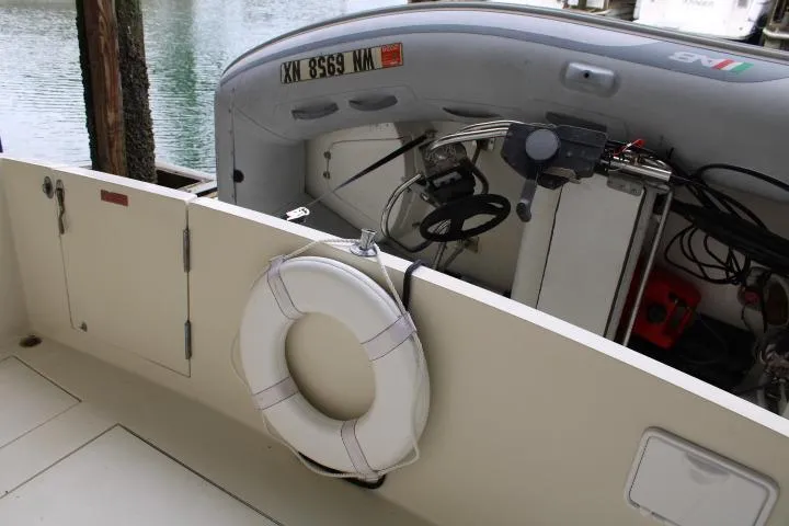 Slide: The Image of 1988 Tollycraft 30 Sport Cruiser with lifebuoy and inflatable boat at dock. - 11