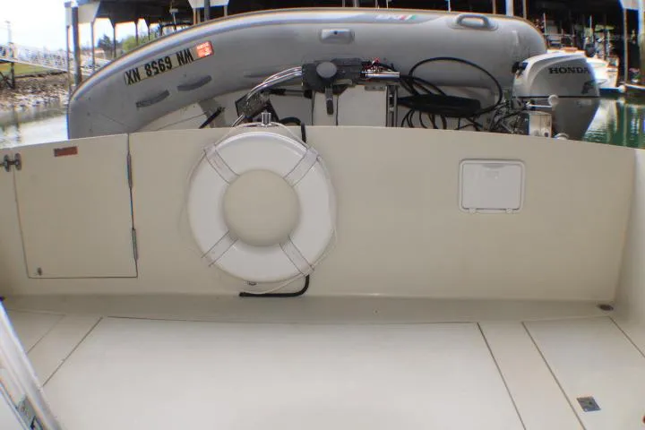 Slide: The Image of 1988 Tollycraft 30 Sport Cruiser with life preserver and dinghy at marina. - 12