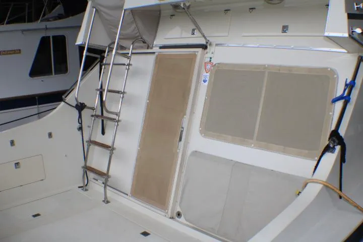 Slide: The Image of 1988 Tollycraft 30 Sport Cruiser deck with ladder and covered windows. - 17