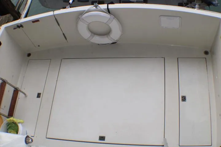 Slide: The Image of 1988 Tollycraft 30 Sport Cruiser deck with life ring and storage compartments. - 18