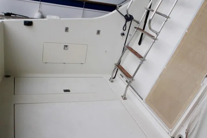 Slide: The Image of 1988 Tollycraft 30 Sport Cruiser deck with ladder and storage compartments. - 19